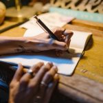 femme écrivant cahier stylo